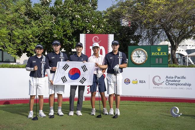 제16회 아시아 퍼시픽 아마추어 챔피언십(AAC)이 열리는 아랍에미리트(UAE) 두바이 에미레이트 골프클럽 마즐리스 코스를 찾은 R&A 홍보대사 송중기(가운데)가 한국 선수들과 태극기를 들고 포즈를 취하고 있다. R&A