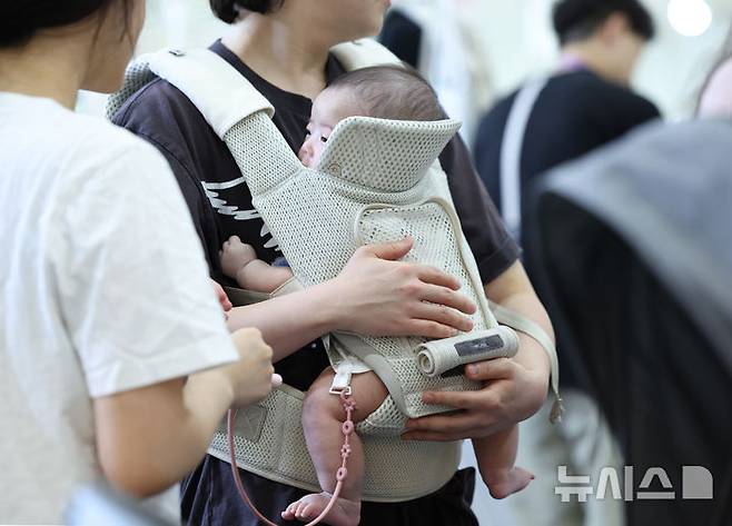 [서울=뉴시스] 김진아 기자 = 14일 서울 강남구 코엑스에서 열린 제48회 베페 베이비페어에서 관람객들이 아기띠를 체험해보고 있다. 2025.08.14. bluesoda@newsis.com