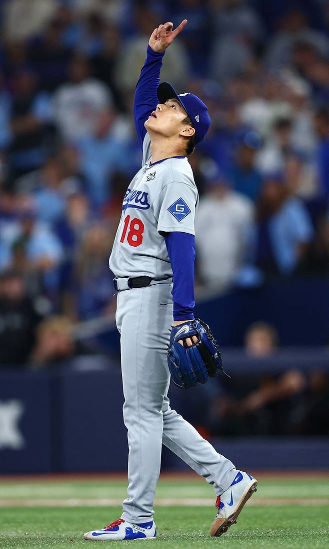 로스앤젤레스(LA) 다저스 야마모토 요시노부가 26일 캐나다 토론토 로저스센터에서 열린 토론토 블루제이스와 2025 MLB 월드시리즈 2차전에서 완투승을 거둔 뒤 오른팔을 번쩍 들며 기뻐하고 있다. 토론토=AP연합뉴스