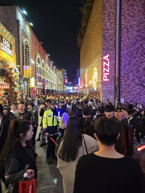 주말인 지난 25일 자정쯤 인파로 빼곡한 용산구 이태원 세계음식거리에서 한 경찰관이 통행을 관리하는 모습. 박효준 기자