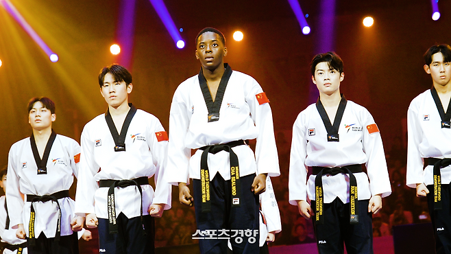 브라이언 칼라무(가운데)가 지난 24일 중국 장쑤성 우시의 타이후 인터내셔널 엑스포 센터에서 열린 2025 세계태권도선수권대회 개막식에서 동료들과 함께 시범을 선보이고 있다. 세계태권도연맹 제공