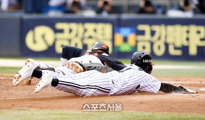 LG 신민재가 26일 잠실구장에서 열린 2025 KBO리그 한화와 한국시리즈 1차전 5회말 1사 3루 오스틴의 3루 땅볼 때 송구가 치우친 틈을 타 3루에서 홈으로 파고들어 득점하고 있다. 잠실 | 박진업 기자 upandup@sportsseoul.com