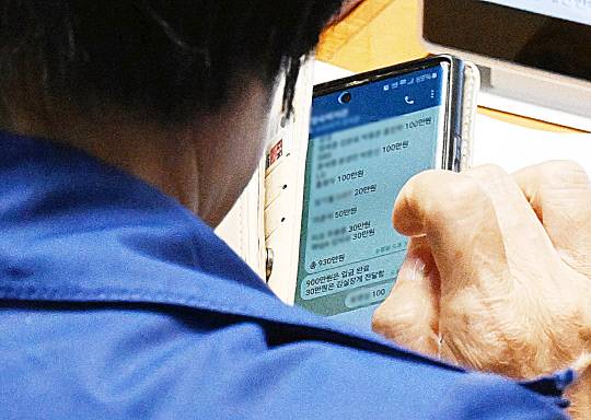 국회 과학기술정보방송통신위원장인 더불어민주당 최민희 의원이 26일 국회 본회의장에서 축의금과 관련한 텔레그램 메시지를 보고 있다. 연합뉴스