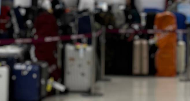 수하물 검색 병목이 심화되며 컨베이어 앞에 짐이 쌓여 있다.