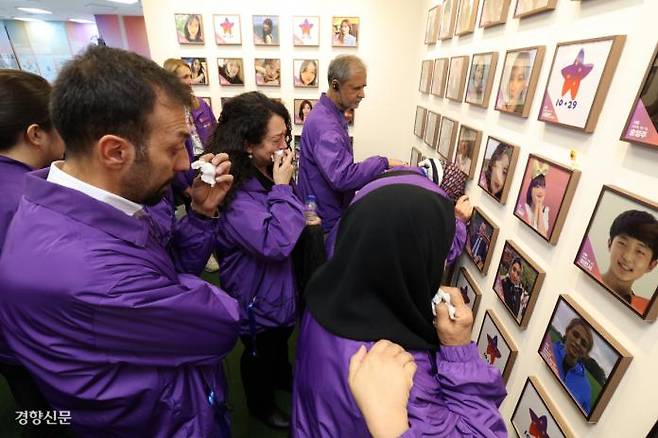 Relatives of foreign victims of the Itaewon crowd crush on October 29, 2022, shed tears after hanging photos of their loved ones on the memorial wall at the “House of Stars” in Jongno-gu, Seoul, on October 26.