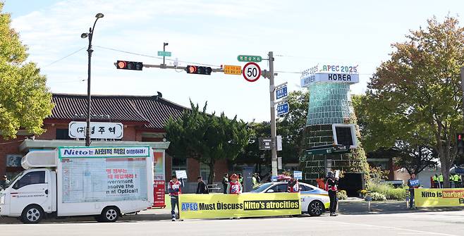 Members of the Korean Optical Hightech Workers’ Union in Gumi, North Gyeongsang, hold a rally calling for the reinstatement of laid-off workers in front of Gyeongju Culture Center 1918, the former Gyeongju Station, in Seongdong-dong, Gyeongju, on Oct. 27, the first day of the 2025 APEC Economic Leaders' Meeting week. [YONHAP]