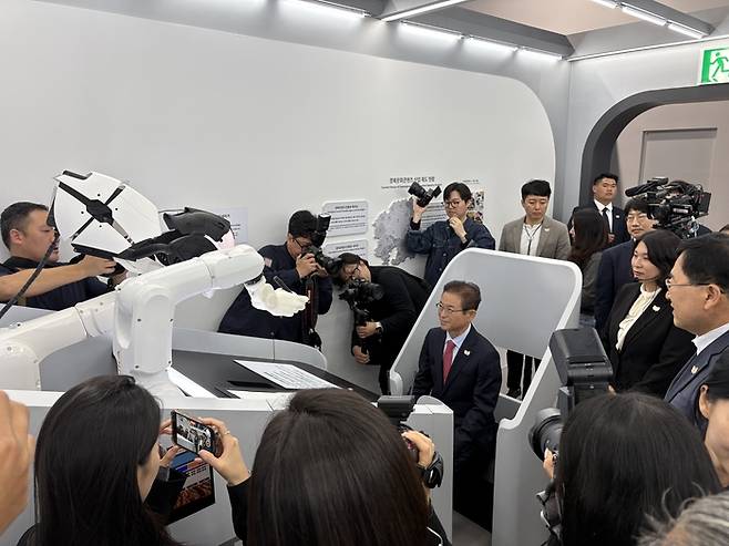 이철우 경북도지사가 APEC 정상회의 경제전시장에 마련된 ‘AI 드로잉 로봇 체험’을 하고 있다.(사진제공-경북도)