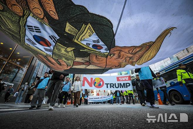 [서울=뉴시스] 정병혁 기자 = 25일 서울 중구 세종대로에서 열린 대미투자 전면 재검토 NO 트럼프 범시민대행진에서 참가자들이 주한민국대사관으로 행진하고 있다. 2025.10.25 jhope@newsis.com
