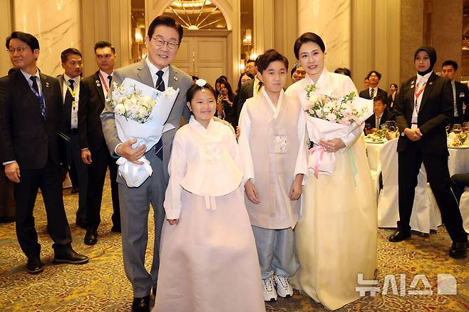 [쿠알라룸푸르=뉴시스] 고범준 기자 = 이재명 대통령과 김혜경 여사가 26일(현지 시간) 말레이시아 쿠알라룸푸르 한 호텔에서 열린 동포 간담회에서 화동에게 꽃다발을 받은 뒤 함께 기념촬영을 하고 있다. 2025.10.26. bjko@newsis.com