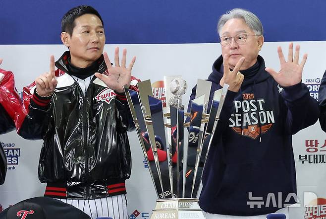 [서울=뉴시스] 김진아 기자 = 염경엽(왼쪽) LG 트윈스 감독과 김경문 한화 이글스 감독이 25일 서울 잠실야구장에서 열린 2025 KBO 한국시리즈 미디어데이에서 우승 트로피와 기념촬영을 하던 중 손가락으로 몇 차전 경기까지 갈 것인지 표시하고 있다. 2025.10.25. bluesoda@newsis.com
