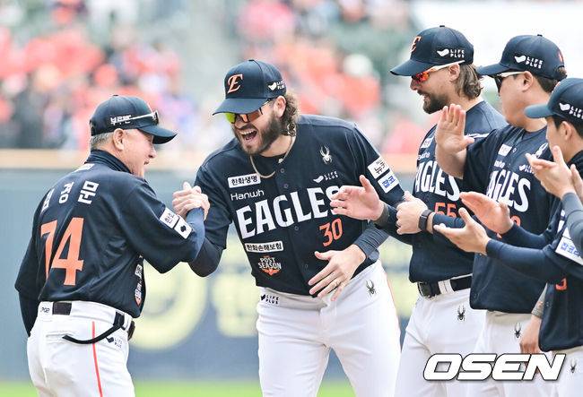 [OSEN=잠실, 박준형 기자] 한 달 가까이 쉰 정규시즌 1위팀이 한국시리즈 1차전에서 이렇게 맹타를 휘두른 경기가 있었나. LG가 시리즈 기선을 제대로 제압하고 우승확률 73.2%를 따냈다.&nbsp;프로야구 LG 트윈스는 26일 서울 잠실구장에서 열린 2025 신한 SOL뱅크 KBO 한국시리즈(7전 4선승제) 한화 이글스와의 1차전에서 8-2로 승리했다.&nbsp;경기 앞서 한화 김경문 감독이 폰세, 와이스, 류현진과 하이파이브를 하며 입장하고 있다.   2025.10.26 / soul1014@osen.co.kr