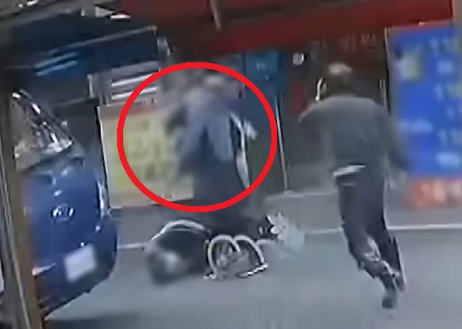 지난 26일 서울 강북구의 한 식당 앞에서 흉기에 찔려 쓰러진 여성 주인을 향해 가해 남성이 다가가자 남편을 비롯한 인근 가게 상인들이 제지하는 모습. YTN 보도화면 캡처