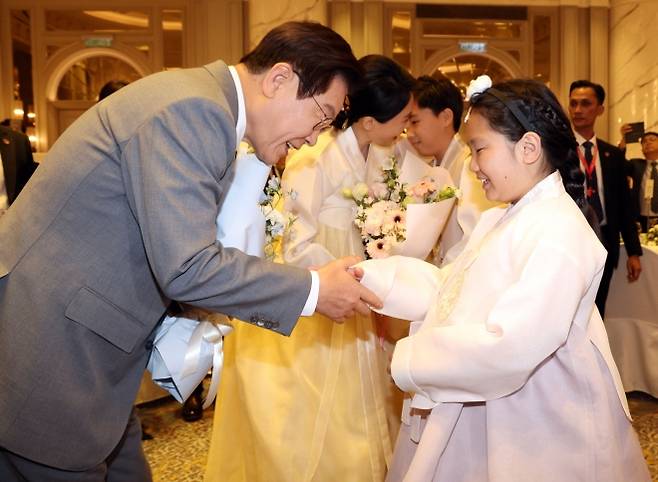 아세안(ASEAN·동남아시아국가연합) 정상회의 참석을 위해 말레이시아를 찾은 이재명 대통령과 김혜경 여사가 26일 쿠알라룸푸르의 한 호텔에서 열린 동포 만찬 간담회에서 화동의 꽃을 받으며 미소 짓고 있다. 쿠알라룸푸르 연합뉴스