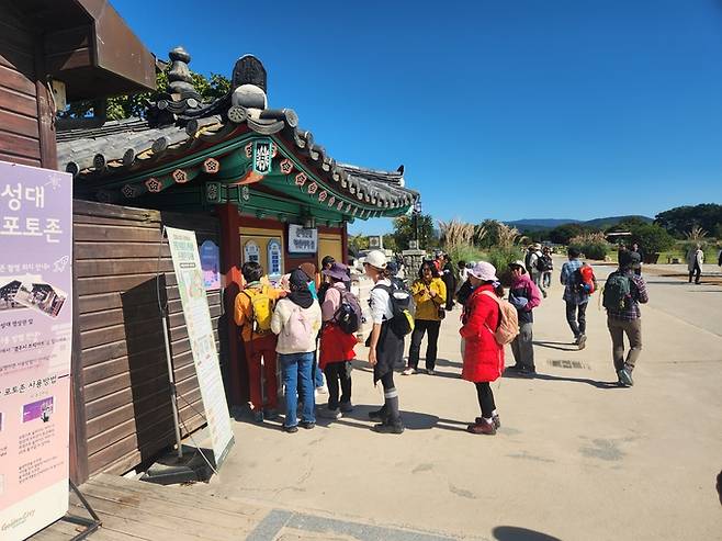 ▲ 첨성대 포토존 앞에 줄 선 관광객들이 안내문을 살펴보며 순서를 기다리고 있다.