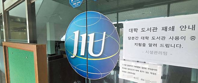 문 닫은 도서관  27일 오전 제주시 제주국제대 도서관 출입문에 ‘당분간 대학 도서관 사용이 중지된다’는 안내문이 붙어 있다. 제주국제대는 재학생(올해 상반기)이 100여 명밖에 없어 수업을 특정 요일에 몰아서 하거나 온라인으로 진행하고 있다. 이날 캠퍼스에서는 학생을 만날 수 없었다./오재용 기자