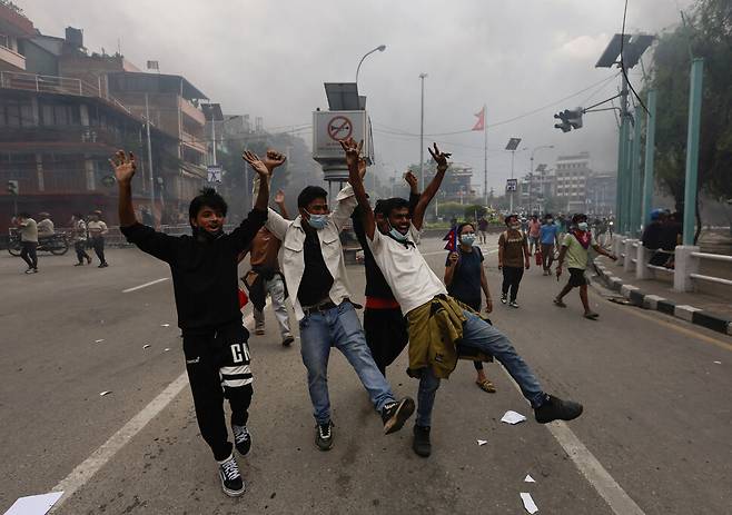 지난달 네팔 카트만두 의회 밖에서 열린 반정부·반부패 시위 도중 한 시위 참여자가 정부가 무너진 뒤 환호하는 모습. 로이터 연합뉴스