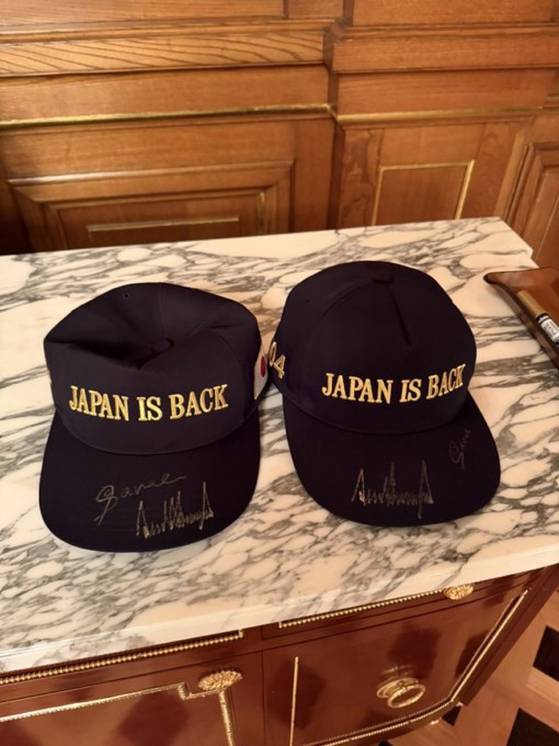 재팬이즈백(일본이 돌아왔다)는 아베 신조 전 총리가 사용하던 문구를 새긴 모자. 아베 전 총리가 사용하던 골프채를 다카이치 사나에 일본 총리가 트럼프 대통령에게 설명하고 있다. 백악관 X 캡처