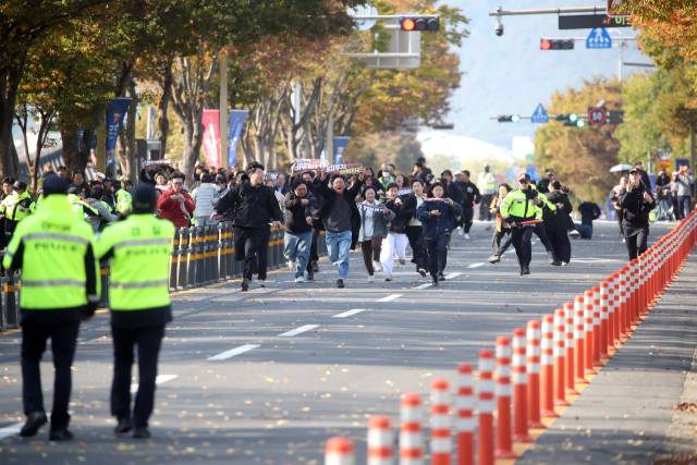 29일 오후 한미 정상회담이 열린 국립경주박물관 인근에서 도널드 트럼프 미국 대통령을 반대하는 기습 시위대가 경찰저지선을 뚫고 정상회담장으로 질주하고 있다. 연합뉴스