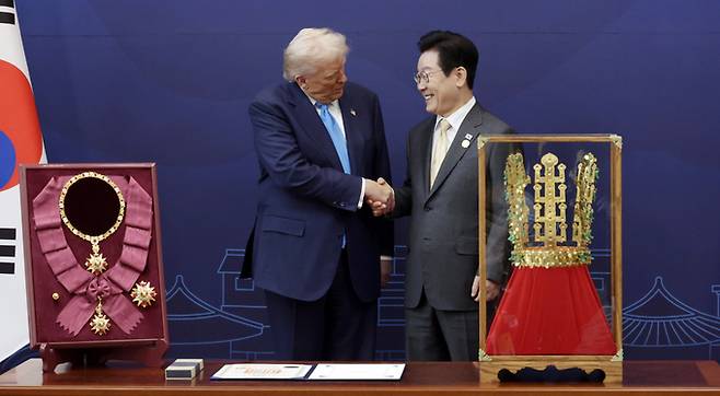 ▲ 이재명 대통령이 29일 경북 경주박물관에서 도널드 트럼프 미국 대통령에게 '천마총 금관 모형'을 선물한 뒤 악수하고 있다. 왼쪽은 이 대통령이 트럼프 대통령에게 수여한 무궁화 대훈장. 대통령실통신사진기자단