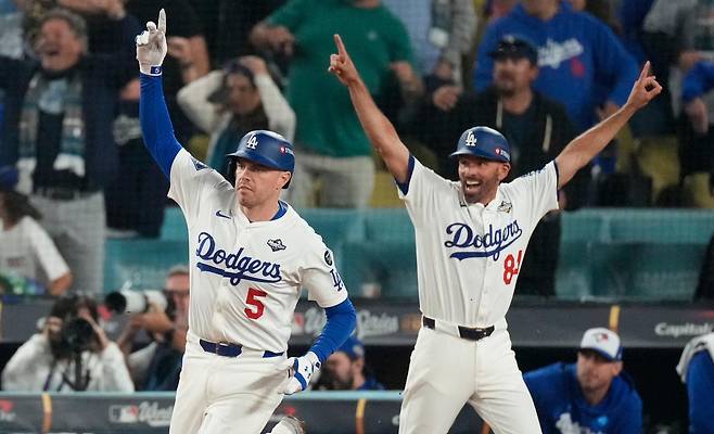 ‘월드시리즈의 사나이’ 프레디 프리먼(LA 다저스·왼쪽)이 28일 미국 로스앤젤레스 다저스타디움에서 열린 토론토와의 미국프로야구 메이저리그 월드시리즈 3차전에서 연장 18회말 끝내기 홈런을 친 뒤 1루 베이스를 돌며 세리머니를 하고 있다. ‘디펜딩 챔피언’ 다저스는 6시간 39분 동안 이어진 혈투 끝에 토론토를 6-5로 꺾고 시리즈 전적 2승 1패로 앞서 나갔다. 오른쪽은 크리스 우드워드 다저스 1루 코치. 로스앤젤레스=AP 뉴시스
