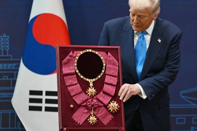 도널드 트럼프 미국 대통령이 29일 경주박물관에서 열린 수훈식에서 이재명 대통령으로부터 대한민국 최고 등급의 훈장인 무궁화대훈장을 받고 있다. 경주=AFP 연합뉴스