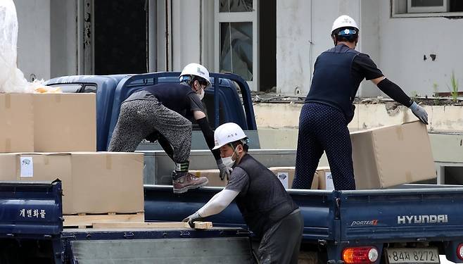 서울의 한 아파트 공사현장에 근로자들이 물건을 나르고 있다. [김호영 기자]