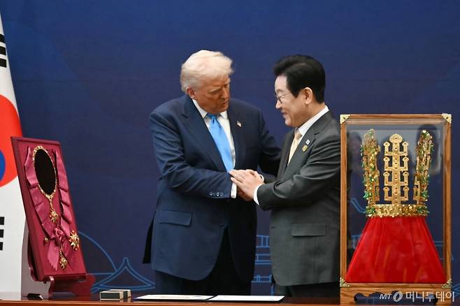 (AFP=뉴스1) = 이재명 대통령이 29일 경북 경주박물관에서 열린 한미 공식 환영식에서 도널드 트럼프 미국 대통령에게 무궁화 대훈장을 수여와 천마총 금관 모형 선물하고 있다.  ⓒ AFP=뉴스1  Copyright (C) 뉴스1. All rights reserved. 무단 전재 및 재배포,  AI학습 이용 금지. /사진=(AFP=뉴스1)