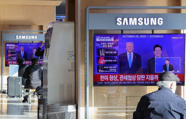 29일 서울역에서 시민들이 도널드 트럼프 미국 대통령 방한 관련 뉴스를 보고 있다. 연합뉴스