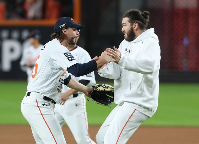 한화 코디 폰세(오른쪽)와 라이언 와이스가 24일 대전한화생명볼파크에서 열린 ‘2025 신한 SOL 뱅크 KBO 포스트시즌(PS)’ 삼성과 플레이오프 5차전을 11-2로 이겨 한국시리즈 진출을 확정한 뒤 함께 기쁨을 나누고 있다. 뉴시스