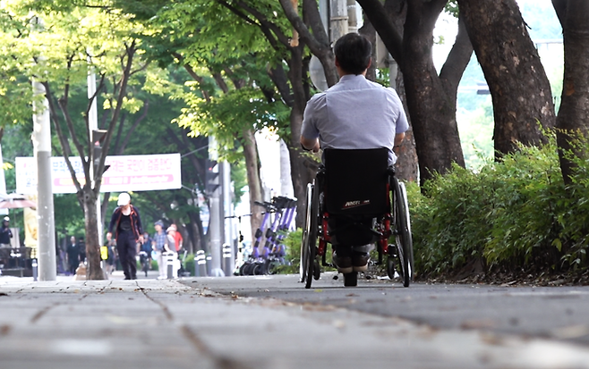 휠체어를 이용하는 송두용씨가 지난 23일 대구 달서구 월곡로를 휠체어로 이동하고 있다. 박지현기자 lozpjh@yeongnam.com