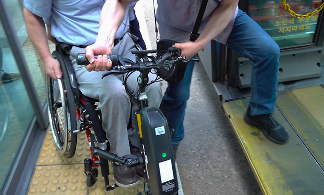 저상버스 리프트가 정상 작동하지 않으면서 버스기사와 승객들이 송두용씨의 휠체어를 들어 올리고 있다. 박지현기자 lozpjh@yeongnam.com