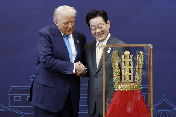 이재명 대통령이 29일 경북 경주박물관에서 도널드 트럼프 미국 대통령에게 '천마총 금관 모형'을 선물한 뒤 악수하고 있다. 사진 대통령실