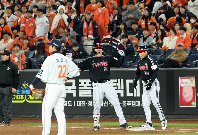 김현수 “1승 남았다” 포효…얼어붙은 관중석  LG 김현수(가운데)가 30일 대전에서 열린 한화와의 한국시리즈 4차전에서 3-4로 뒤지던 9회초 2사 2·3루에서 2타점 적시타로 역전시킨 뒤 환호하고 있다. 연합뉴스