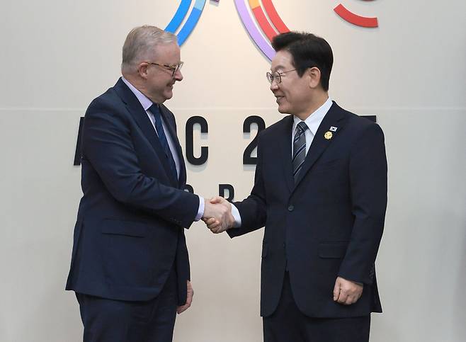 South Korean President Lee Jae Myung (right) and Australian Prime Minister Anthony Albanese shake hands at their summit in Gyeongju, North Gyeongsang Province, Thursday. (Joint Press Corps via Yonhap)