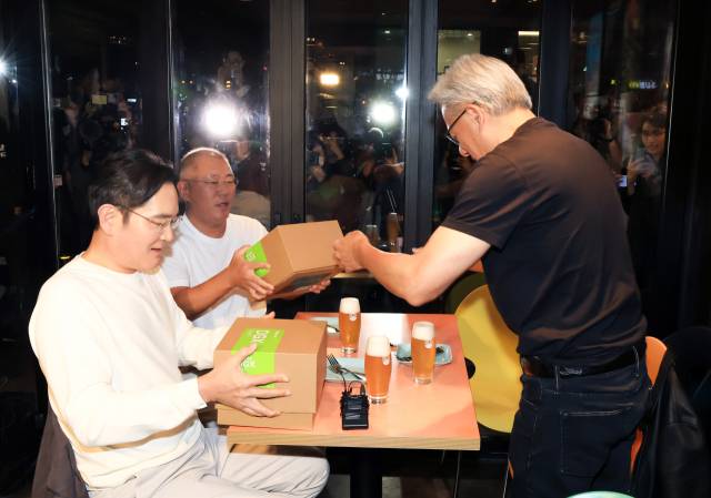 젠슨 황 엔비디아 최고경영자(CEO)가 30일 오후 서울 강남구 삼성역 인근 깐부치킨 매장에서 진행된 회동에서 이재용 삼성그룹 회장, 정의선 현대차그룹 회장에게 선물을 전달하고 있다. [연합뉴스]