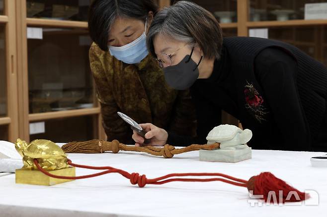 [서울=뉴시스] 박진희 기자 = 국립고궁박물관 수장고 속 왕실 유산 심층조사가 열린 30일 서울 종로구 국립고궁박물관 열린수장고에서 박선경 매듭장 전승교육사와 박선희 매듭장 이수자가 1667년 제작한 '숙종 왕세자책봉 옥인'을 심층조사 하고 있다. 2025.10.232025.10.00. pak7130@newsis.com