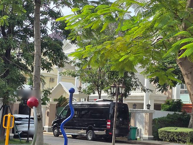 26일 오후(현지시간) 한국 청년들이 갇혀있는 것으로 추정되는 캄보디아 프놈펜의 한 고급주택 앞에 소형버스 등이 주차돼있다. 연합뉴스