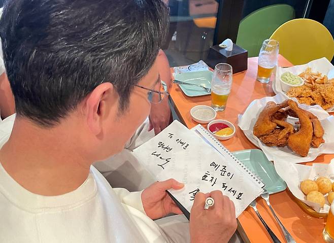 이재용 삼성전자 회장이 30일 서울 삼성동 한 치킨집에서 진행된 젠슨 황 엔비디아 최고경영자, 정의선 현대차그룹 회장과의 치맥 회동에서 한 어린이에게 사인을 한뒤 '효자되세요'라고 쓰고 있다. /연합뉴스