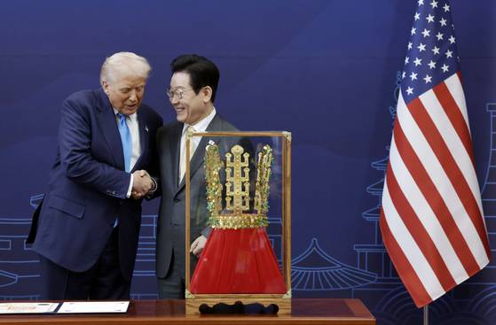 이재명 대통령이 29일 경북 경주박물관에서 도널드 트럼프 미국 대통령에게 '천마총 금관 모형'을 선물한 뒤 악수하고 있다. 연합뉴스