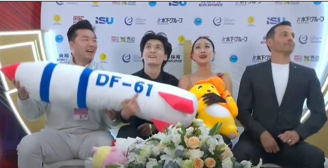 중국 피겨스케이팅 런쥔페이와 싱자닝 조가 점수를 기다리며 미사일 모양의 인형을 들고 있다. [사진 유튜브 영상 캡처]