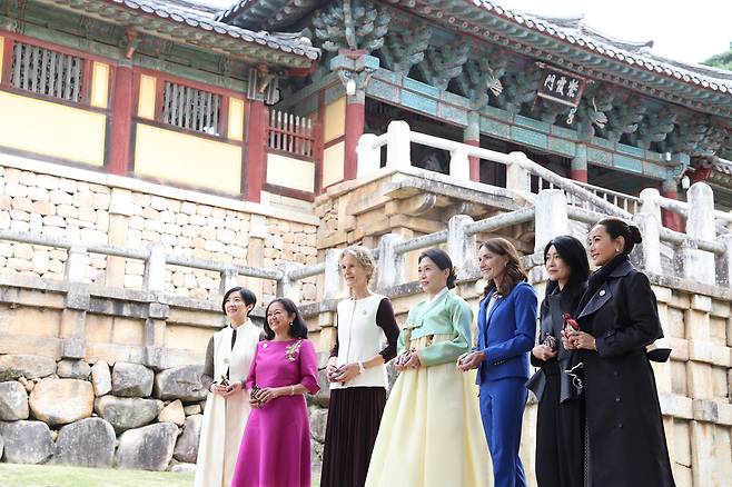 First lady Kim Hea Kyung (center) poses with companions of global leaders during the APEC 2025 Leaders’ Spouses Program at Bulguksa in Gyeongju, North Gyeongsang Province, Friday. From left: Lin Wen-hsuan, daughter of Taiwan's senior presidential advisor Lin Hsin-i, Louise Araneta-Marcos of the Philippines, Diana Fox Carney of Canada, Kim, Amanda Luxon of New Zealand, Ruth Lui of Singapore, and Thinanon Niramit of Thailand. (Yonhap)