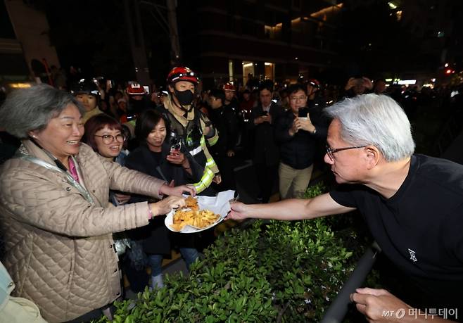 (서울=뉴스1) 김진환 기자 = 젠슨황 엔비디아 최고경영자가 30일 이재용 삼성전자 회장, 정의선 현대자동차그룹 회장과 서울 강남구 깐부치킨 매장에서 치킨 회동 중 밖으로 나와 시민들에게 치킨 등을 나눠주고 있다. (공동취재) 2025.10.30/뉴스1  Copyright (C) 뉴스1. All rights reserved. 무단 전재 및 재배포,  AI학습 이용 금지. /사진=(서울=뉴스1) 김진환 기자