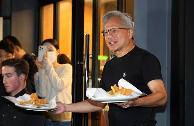 젠슨 황 엔비디아 최고경영자가 30일 서울 삼성동 한 치킨집에서 진행된 이재용 삼성전자 회장, 정의선 현대차그룹 회장과 치맥 회동 중 시민에게 치킨과 감자튀김을 나눠주고 있다. 연합뉴스