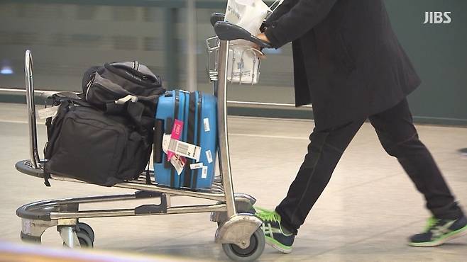 공항 수하물 카트를 밀고 이동하는 여행객. 늘어난 관광 수요와 이동의 속도를 보여주는 장면이다.