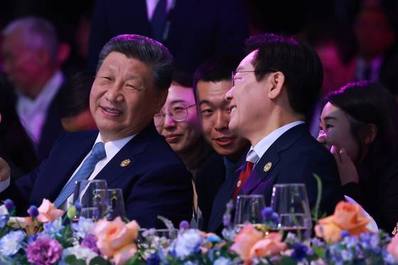 Korean President Lee Jae Myung, right, chats with Chinese President Xi Jinping during the APEC summit gala dinner at the Lahan Select hotel in Gyeongju, North Gyeongsang, on Oct. 31. [YONHAP]