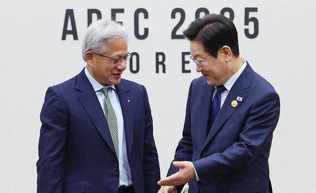 이재명 대통령이 31일 APEC 정상회의장인 경주화백컨벤션센터에서 젠슨 황 엔비디아 최고경영자와 면담 전 기념 촬영을 마친 뒤 자리를 안내하고 있다.  연합뉴스