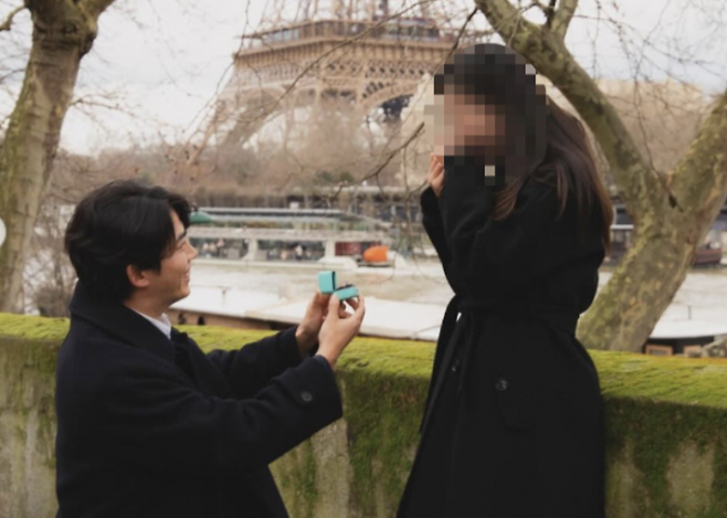 그룹 2PM 멤버 겸 배우 옥택연(왼쪽)이 1일 결혼을 발표했다. 사진은 올해 2월 온라인 커뮤니티를 중심으로 확산한 옥택연 사진. 프랑스 파리 에펠탑 앞에서 여자친구에게 프러포즈하는 듯한 모습이 담겼다.