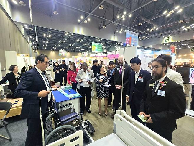 김민철 경상원장이 미국 조지아 경제사절단 등과 '소공인 박람회' 참가사의 제품 설명을 듣고 있다. <경기도시장상권진흥원 제공>