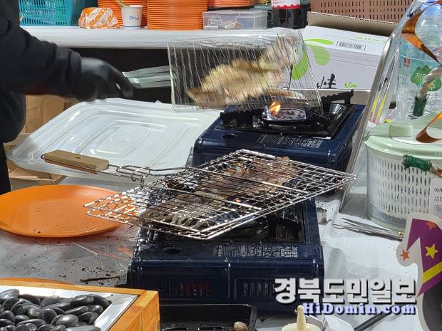 포항 송도해수욕장에서 개최된 해양미식축제 음식운영부스 관계자들이 따뜻한 쥐포를 굽고 있다.