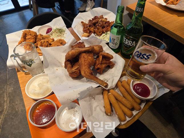 크리스피·식스팩·스윗순살·치즈스틱·치즈볼까지, 깐부치킨 ‘총수 세트’ 한상차림. 테슬라 조합(테라+참이슬)도 빠지지 않았다. (사진=한전진 기자)